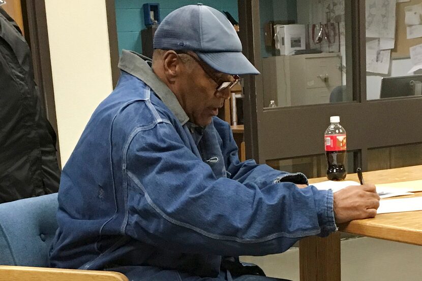 O.J. Simpson signs documents at the Lovelock Correctional Center, Saturday, Sept. 30, 2017,...