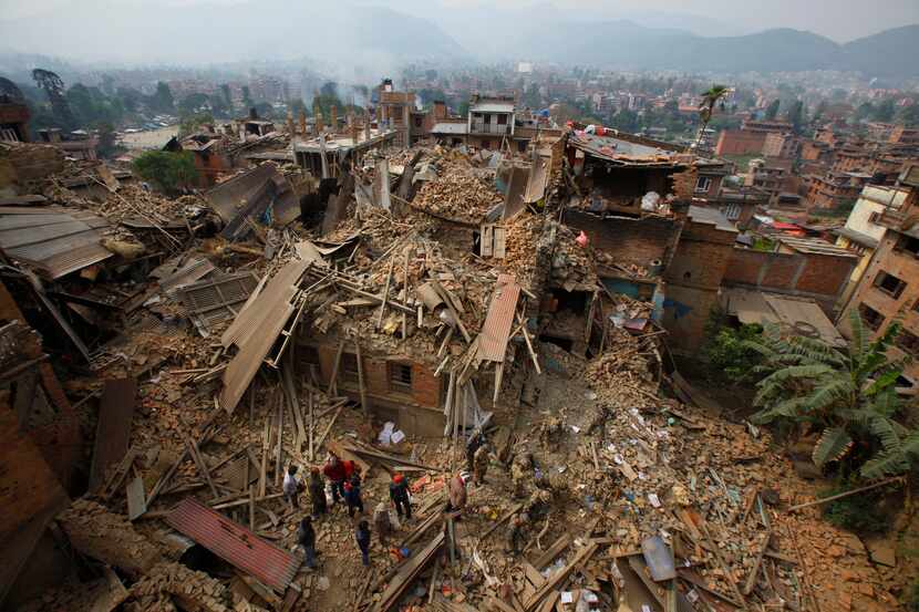 Rescue workers remove debris as they search for victims of earthquake in Bhaktapur near...