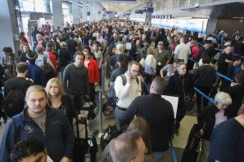  Passengers at O'Hare International Airport wait in line to be screened at a Transportation...