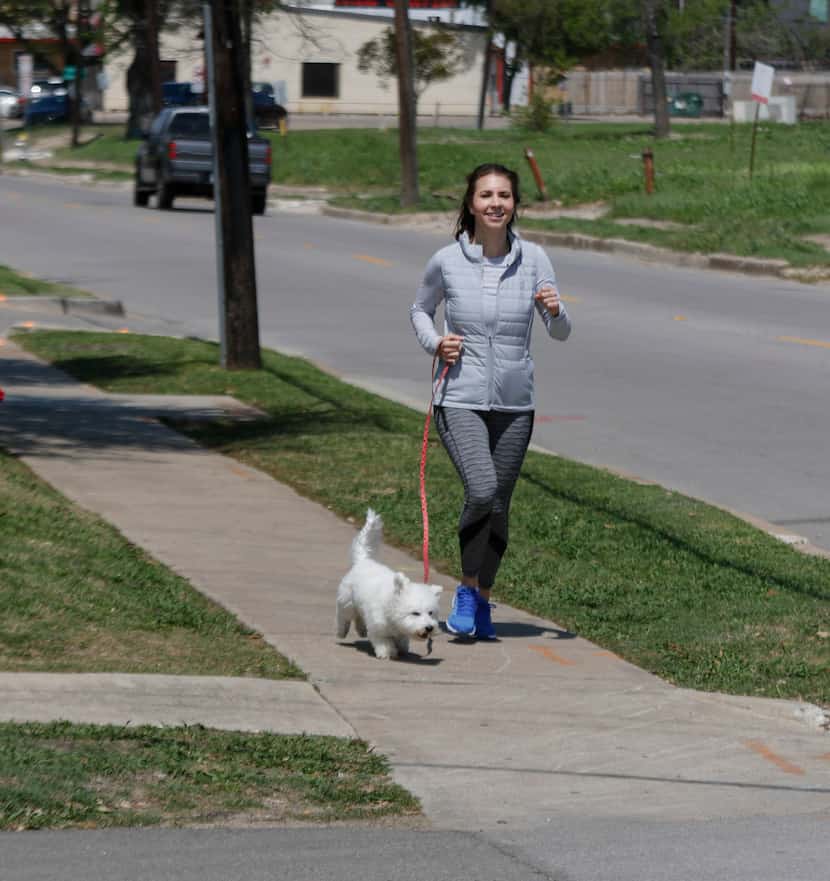Aly Christensen, walks her dog, Coconut, along  the 2100 block of North Henderson Avenue in...