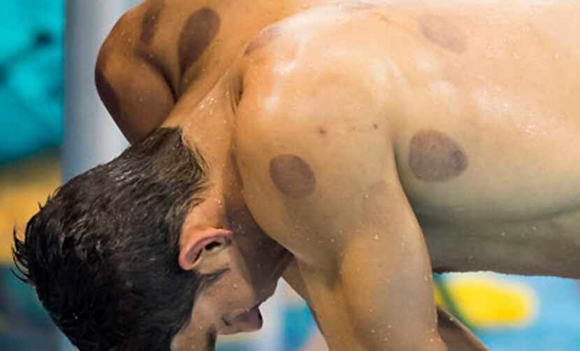 Michael Phelps catches his breath after swimming the anchor leg of the men's 2X200m...