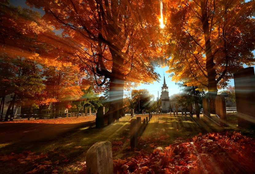 In this photo taken with a slow shutter speed, autumn's colors peak on hardwood trees in a...