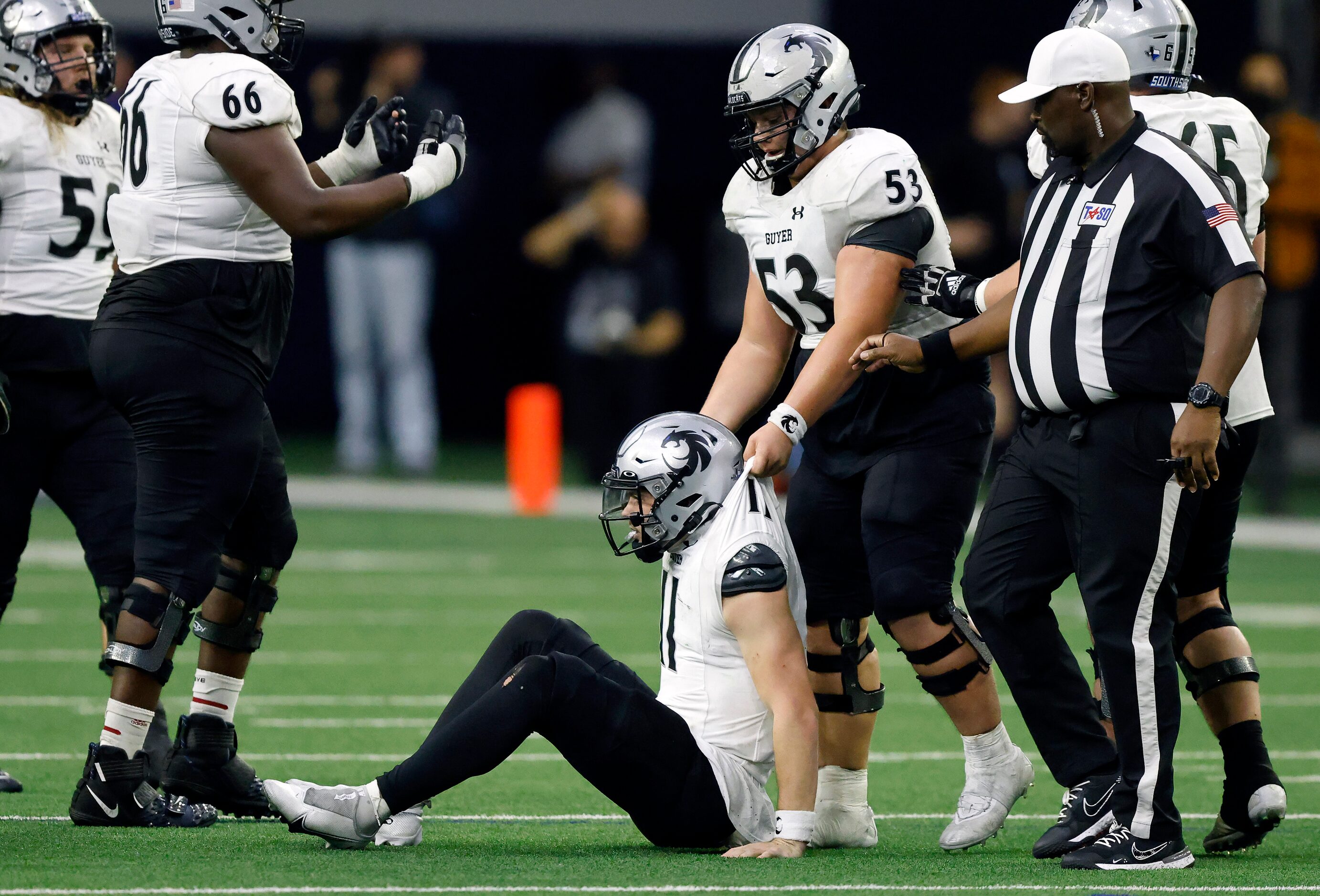 Denton Guyer quarterback Jackson Arnold (11) is helped to his feet by teammate Isaiah Davis...