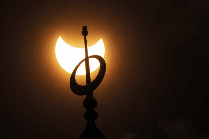 El minarete de la mezquita Mohammad Al-Amin visto contra el eclipse parcial de Sol, en el...