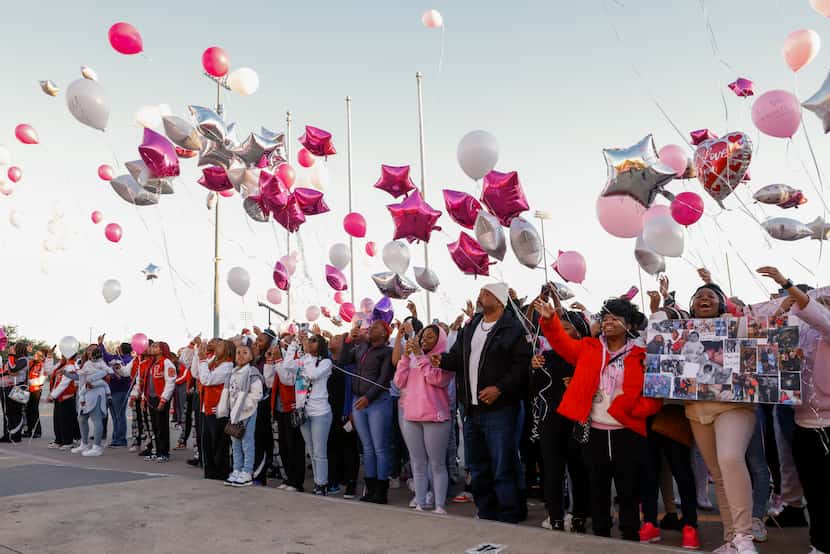 People released pink and white balloons during a memorial for Ikea Imari Hood, 17, outside...