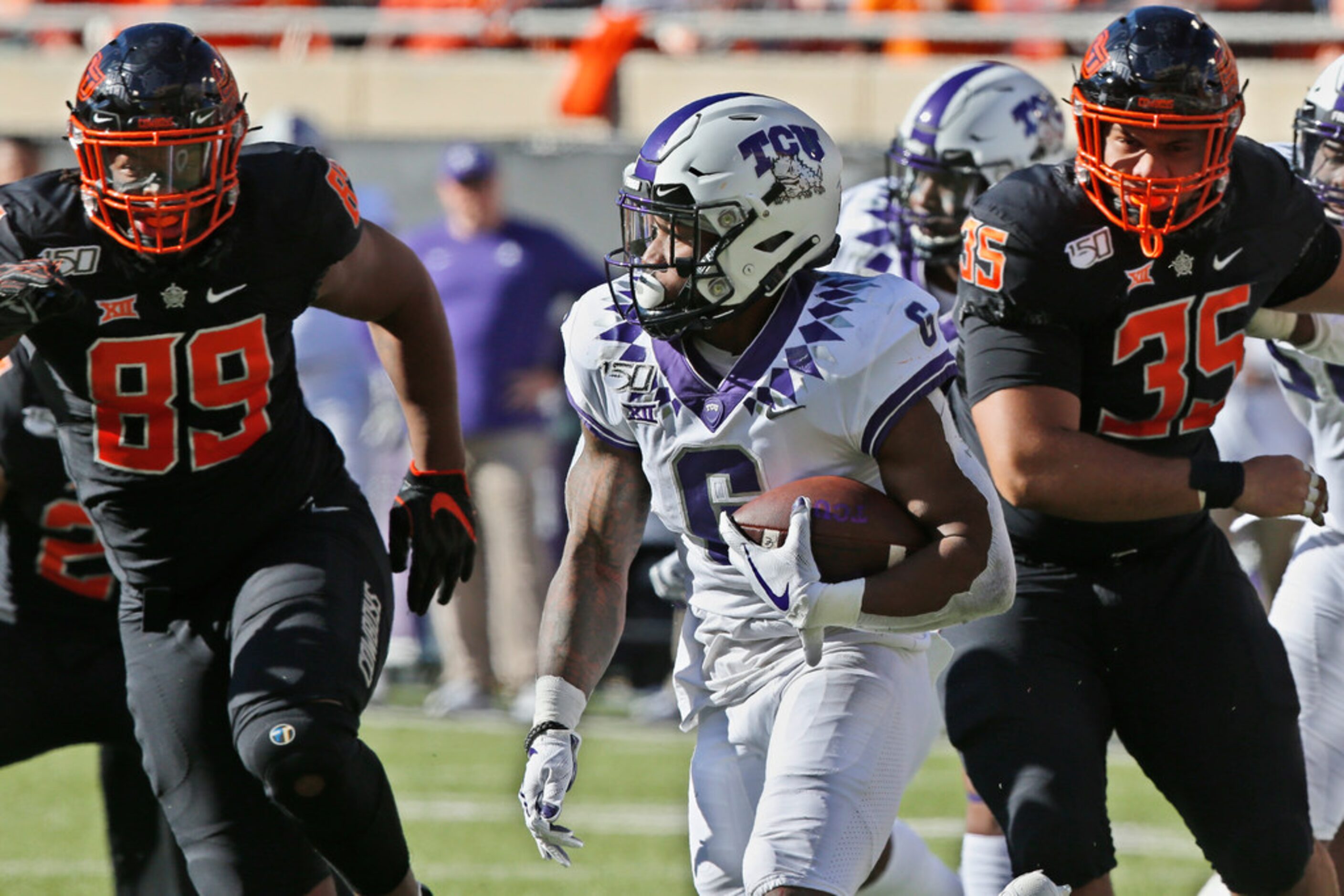 TCU running back Darius Anderson (6) carries past Oklahoma State defensive end Tyler Lacy...