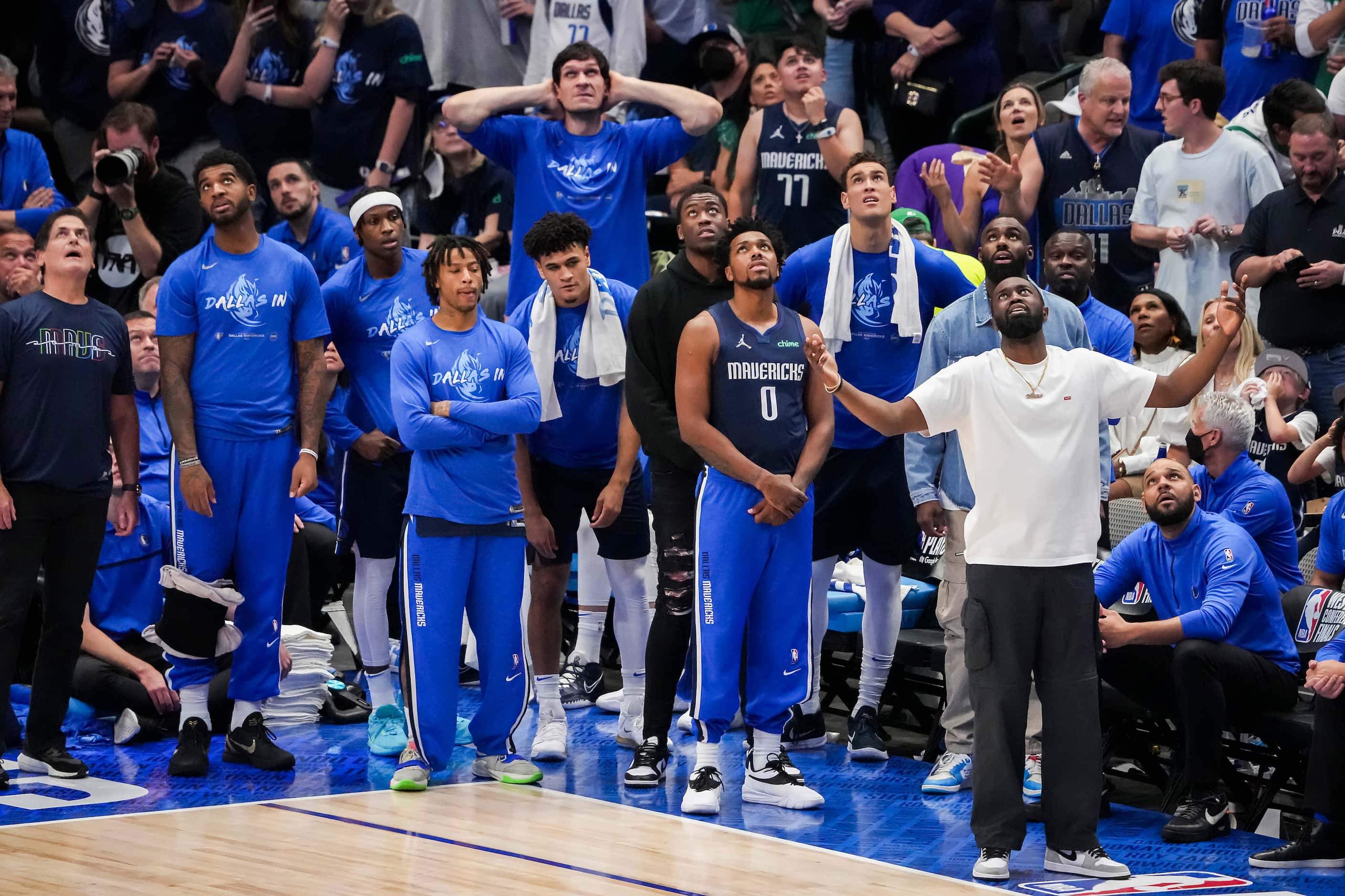 Dallas Mavericks guard Theo Pinson (in white) reacts on the bench after a foul call went...