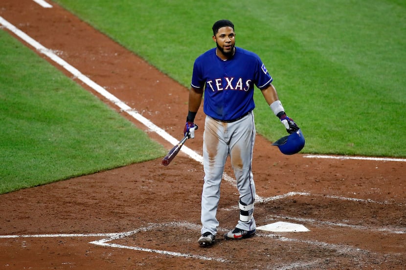 Texas Rangers' Elvis Andrus walks toward the dugout after striking out swinging during the...