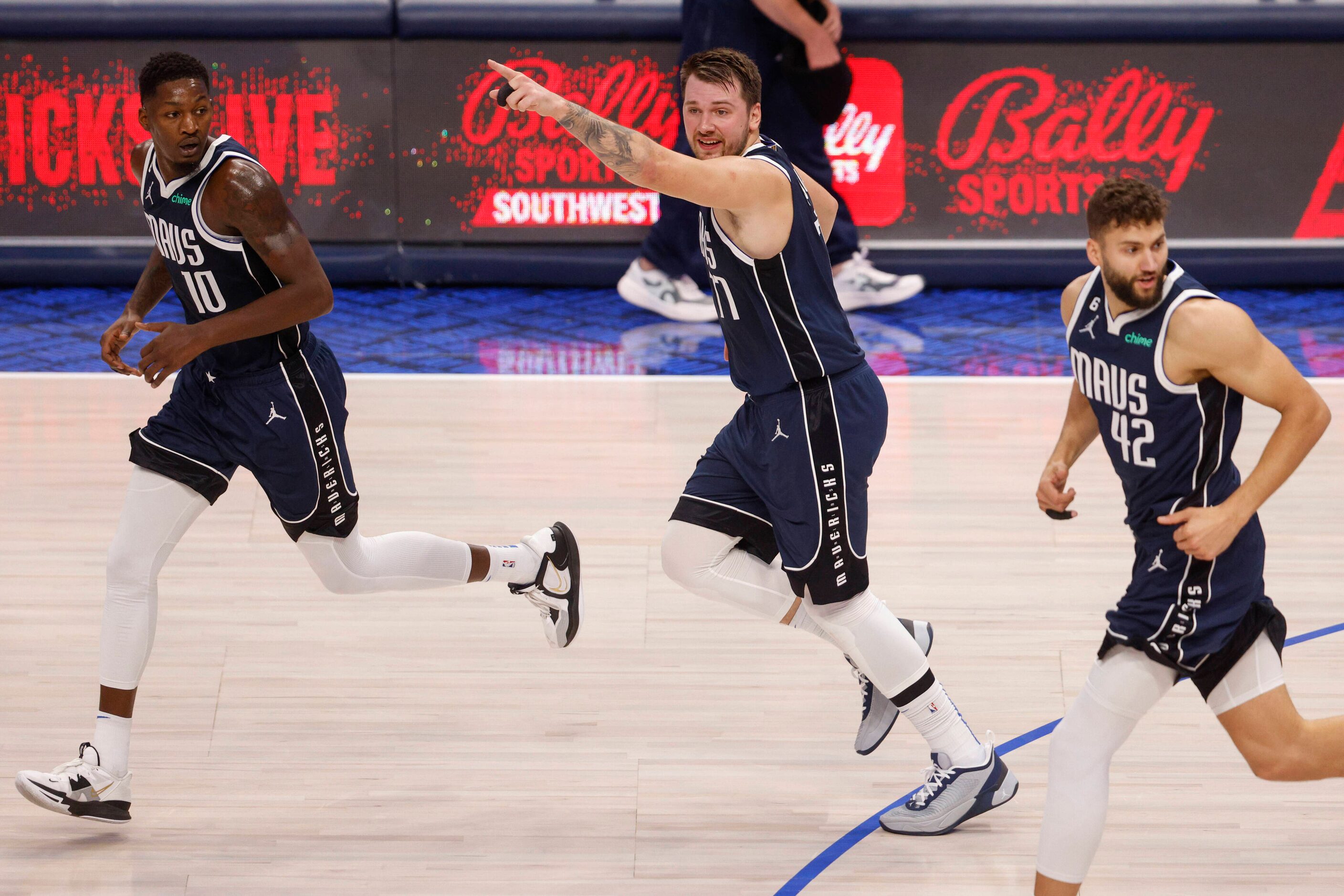 Dallas Mavericks guard Luka Doncic (77) points as he runs back on defense with forward...