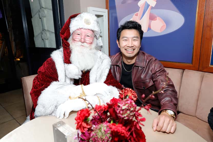 Canadian actor Simu Liu sits with Santa at the Neiman Marcus lauch event Tuesday. 
