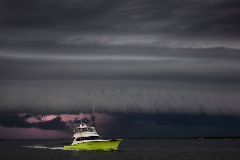 A boat heads for the safety of Dennis Dryer Municipal Harbor in late July as a fast-moving...