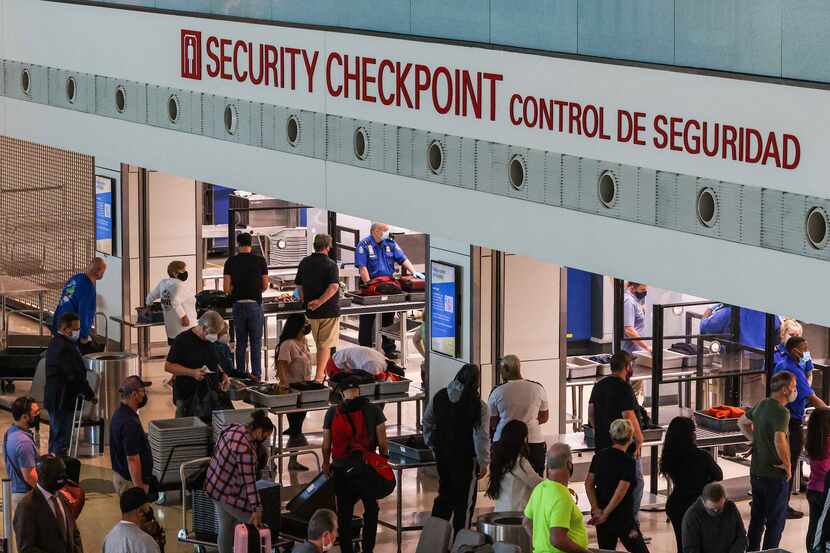 Travelers go through security checkpoint at the Dallas Love Field airport in Dallas....