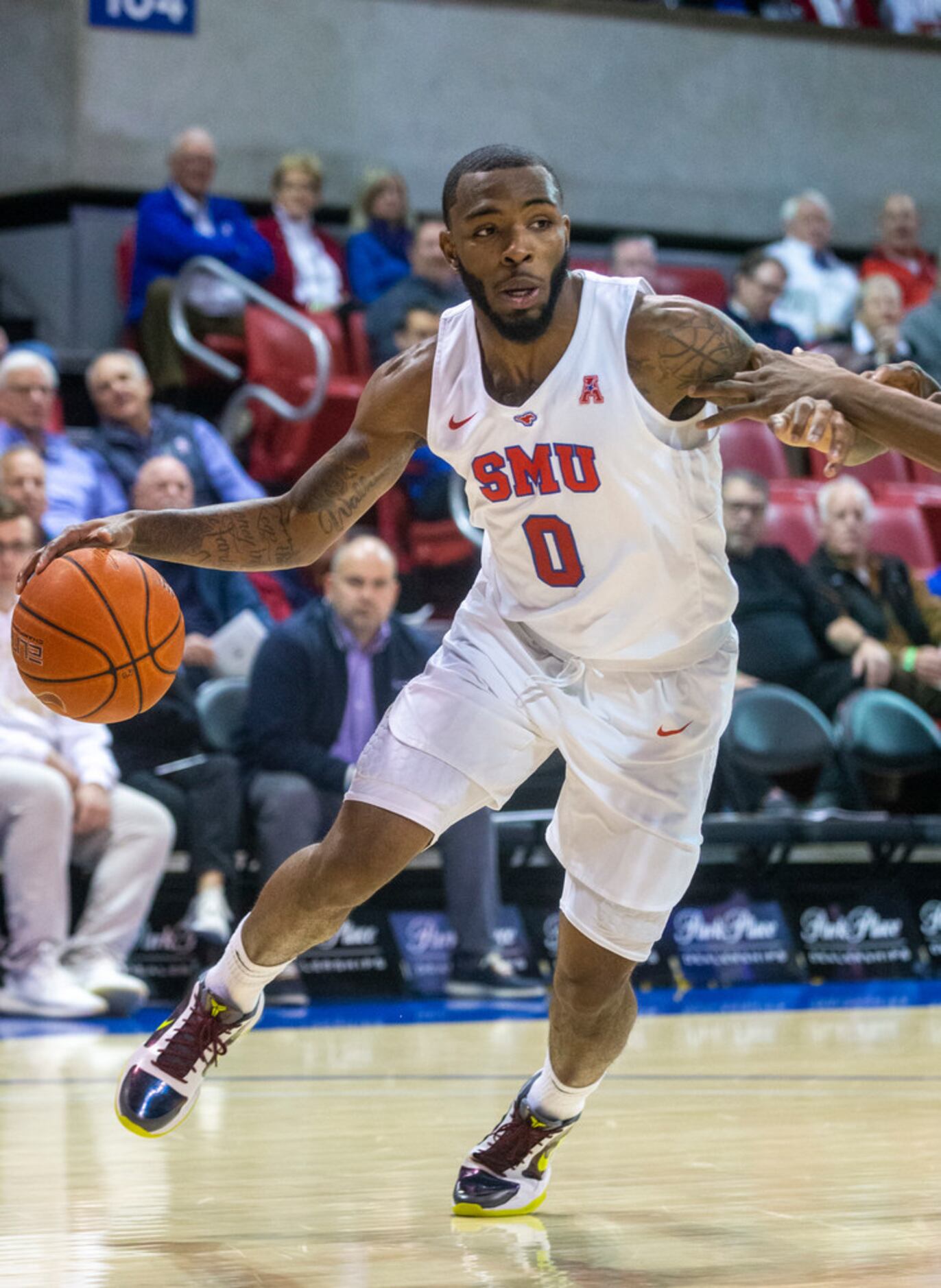Southern Methodist Mustangs guard Tyson Jolly (0) drives the ball past defenders in the...