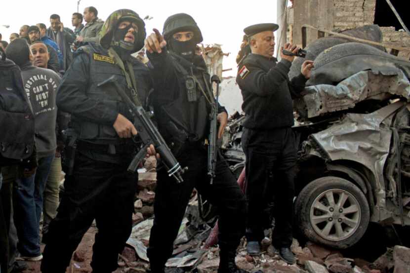 Egyptian security forces gathered at the scene of an explosion at police headquarters in...