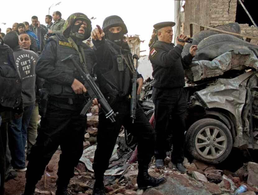 Egyptian security forces gathered at the scene of an explosion at police headquarters in...