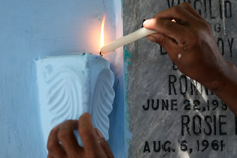 A man lights candles at the tomb of departed loved ones at Manila's North Cemetery,...