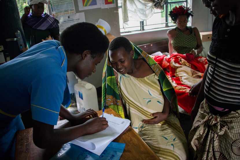 After being delivered by the boda boda, a nurse checks the mother into the health facility....
