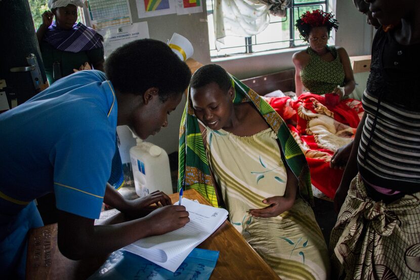 After being delivered by the boda boda, a nurse checks the mother into the health facility....