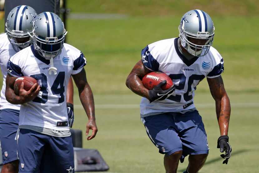 Dallas Cowboys running back Daren McFadden (20) participates in drills as Ryan Williams (34)...