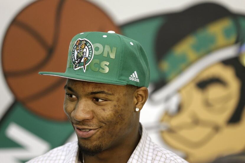Boston Celtics 2014 NBA basketball draft pick Marcus Smart stands in front of a Boston...