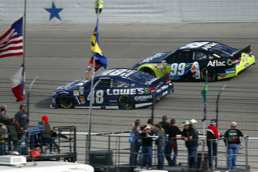 NASCAR Sprint Cup Series driver Jimmie Johnson (48) and pole sitter  Carl Edwards (99) race...