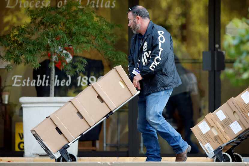 Dallas police carted boxes of files from the Catholic Diocese of Dallas during a raid last...
