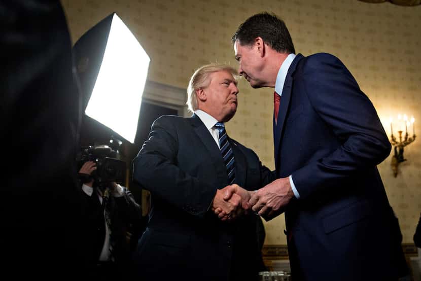 President Donald Trump shakes hands with James Comey, then director of the FBI, in the Blue...