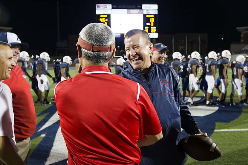 Allen head coach Tom Westerberg clutches a game ball as he celebrates with his assistants...