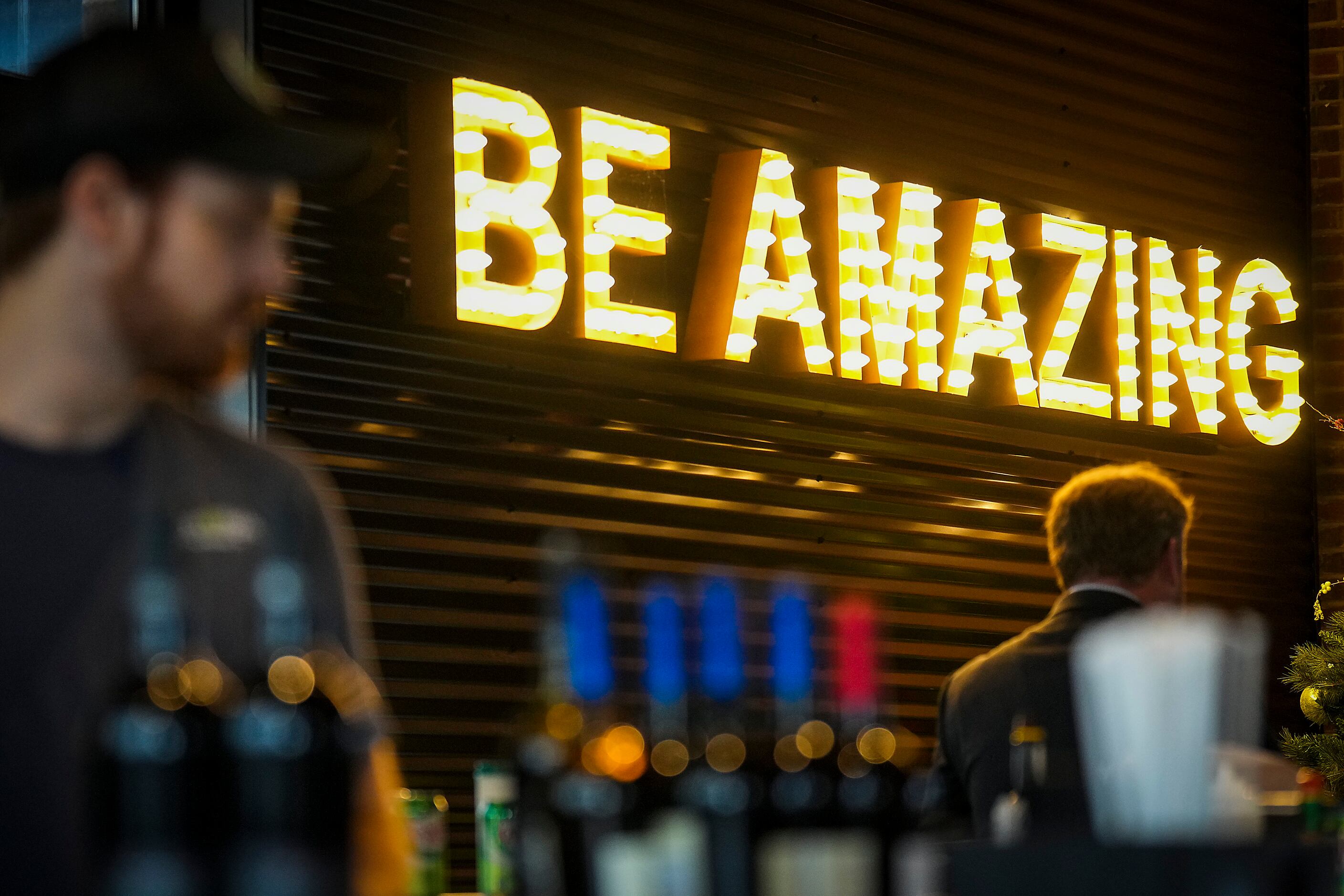 A sign in a bar area reads “Be Amazing” at Chicken N Pickle on Friday, Dec. 9, 2022, in...