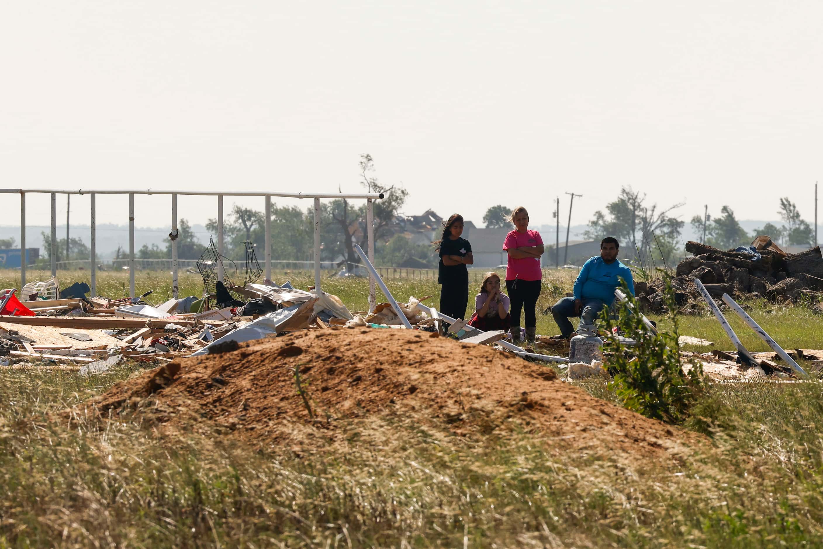 A family sits by their destroyed house, on Sunday, May 26, 2024, in Valley View, after a...