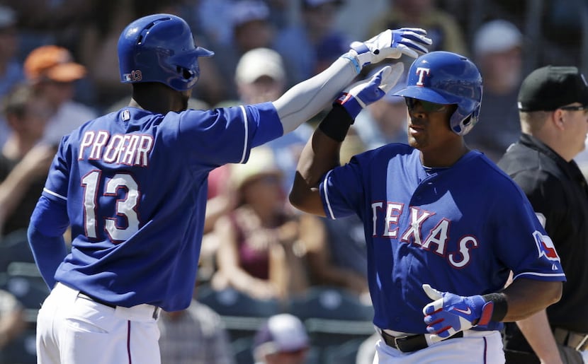 Texas Rangers' Adrian Beltre is congratulated by Jurickson Profar after scoring during the...