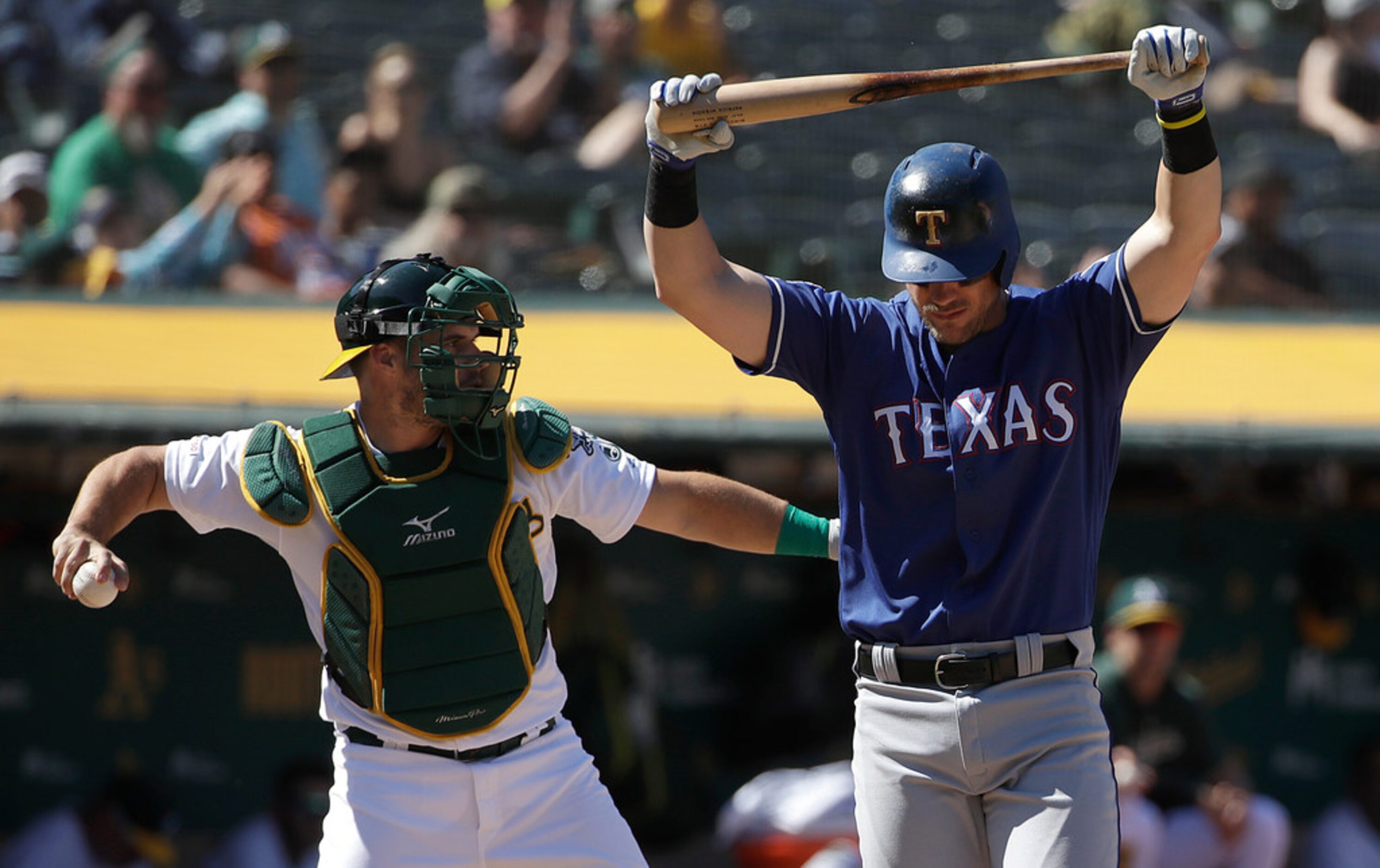 Texas Rangers' Patrick Wisdom, right, reacts after striking out in front of Oakland...