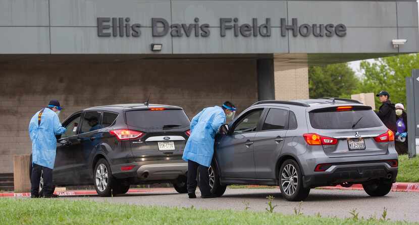 Medical professionals screen patients before letting them into a testing site at Ellis Davis...
