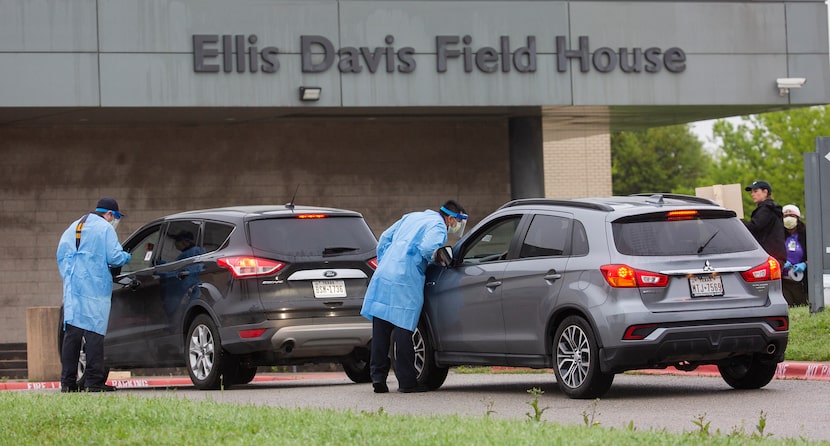 Medical professionals screen patients before letting them into a testing site at Ellis Davis...