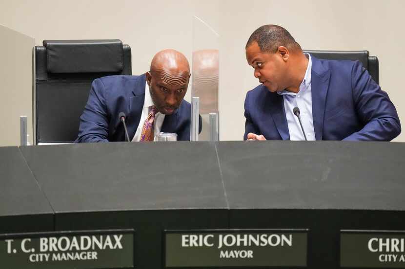 Dallas City Manager T.C. Broadnax (left) and Mayor Eric Johnson confer as they listen to...