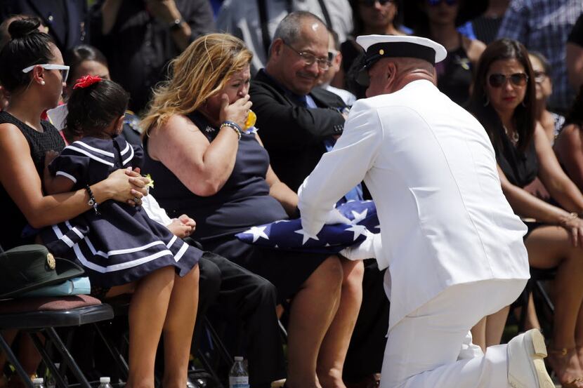 Valerie Zamarripa is overcome with emotion as Navy Senior Chief Cesar Rodriguez of NAS Joint...