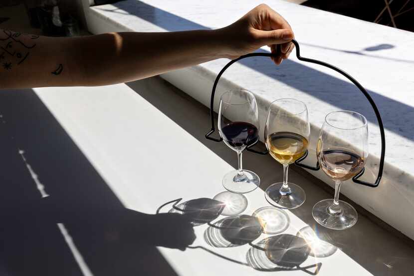Daniela Arboleda, manager at The Holly, holds a tasting flight of red, orange wine and rose.