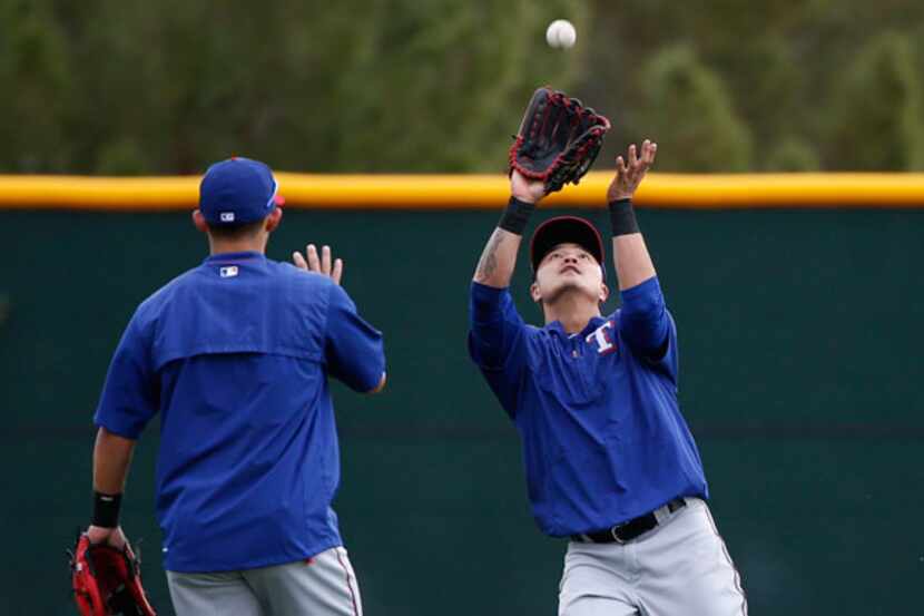 Rangers outfielder Shin-Soo Choo makes a catch in a fielding drill during a workout at the...