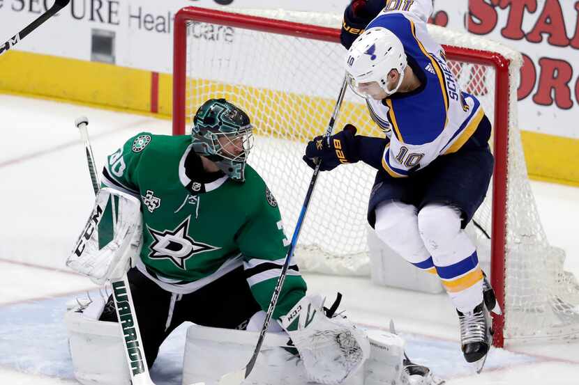 Dallas Stars' Ben Bishop (30) deflects a shot with his leg under pressure from St. Louis...