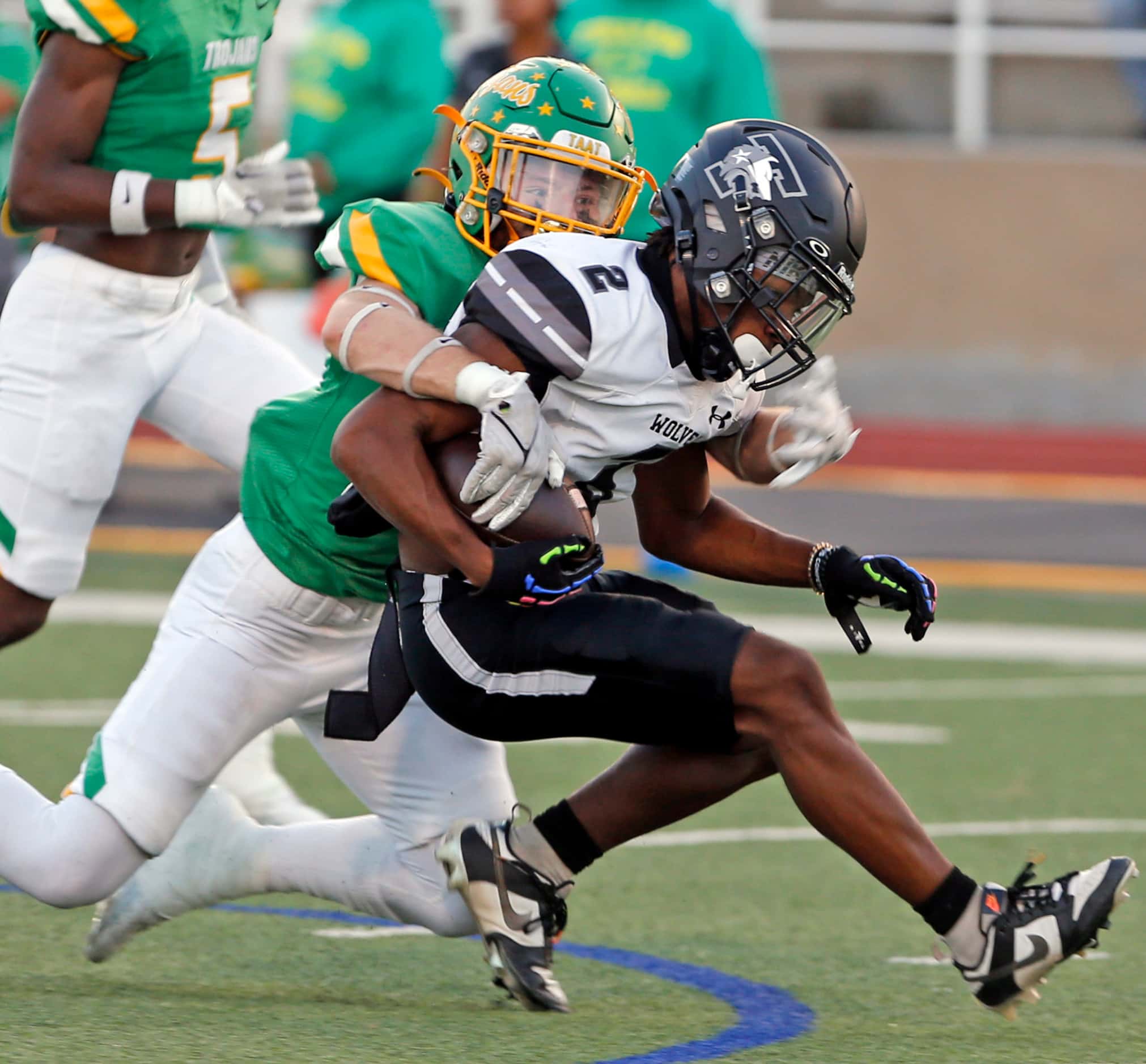 Mansfield Timberview high WR Tyler Madison (2) is grabbed from behind by a Newman Smith high...