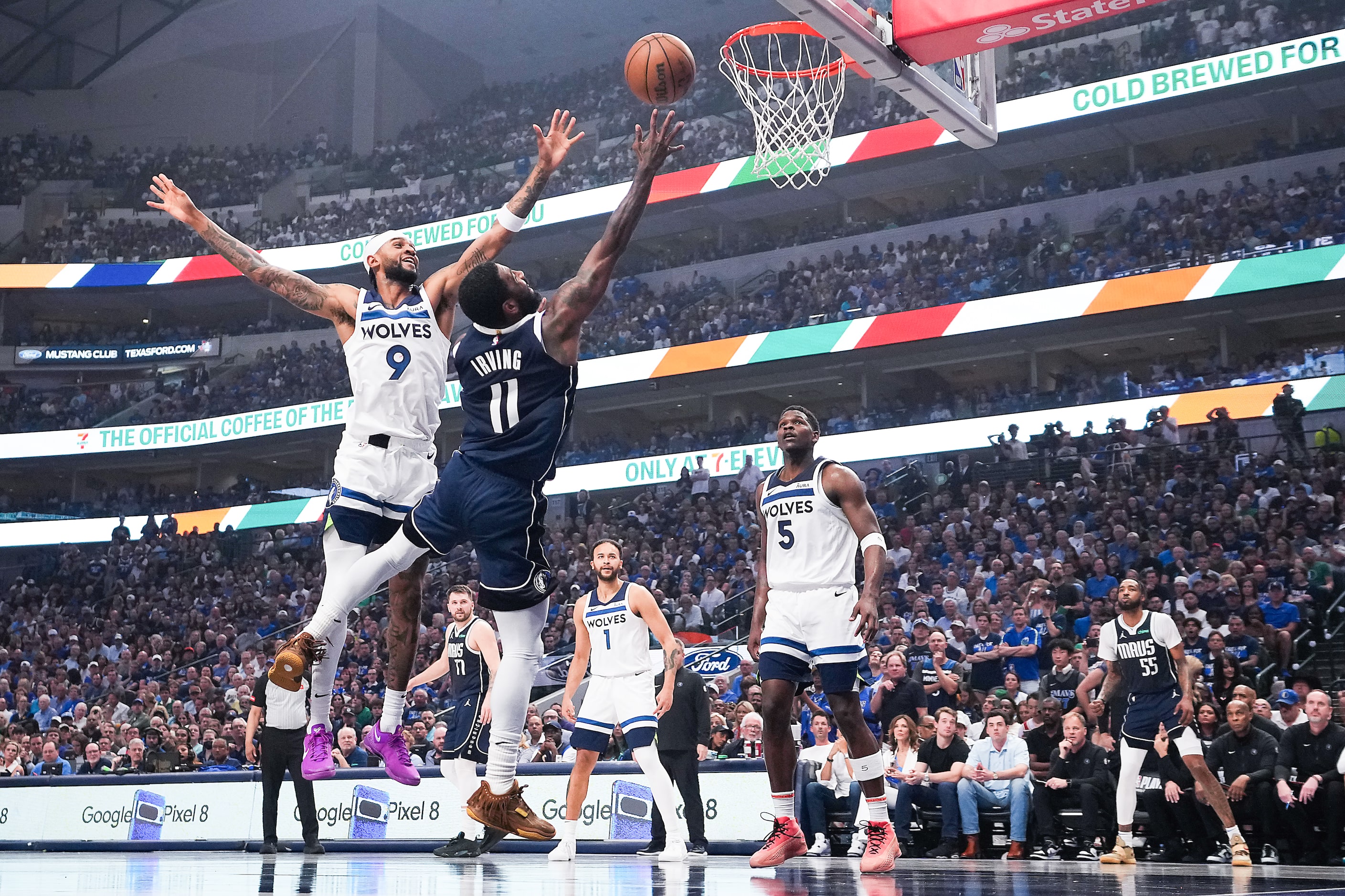 Dallas Mavericks guard Kyrie Irving (11) shoots past Minnesota Timberwolves guard Nickeil...