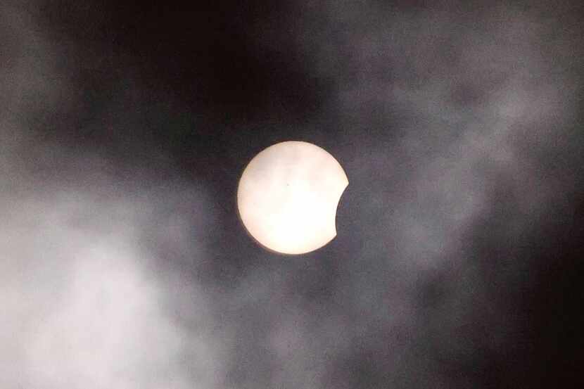 La luna comienza a cubrir el sol, en medio de un cielo mayormente nublado en Dallas, este 8...