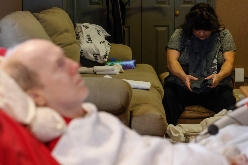Community care attendant Angela Blankenship (right) folds laundry of Rick Frame, 59, of...