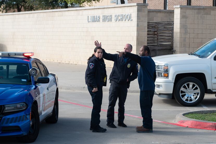 Lamar High School parent Tim Allen, 50, right, speaks to Arlington Police Officers asking...