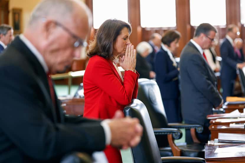 State Sen. Angela Paxton, R-McKinney, center, and other state senators, pray during the...