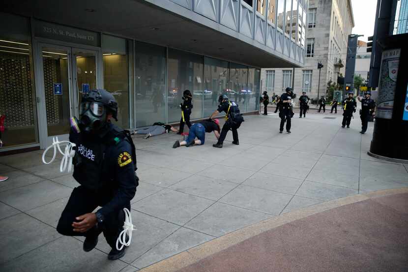 Dallas police begin clearing downtown Dallas as a 7 p.m. curfew begins Sunday.
