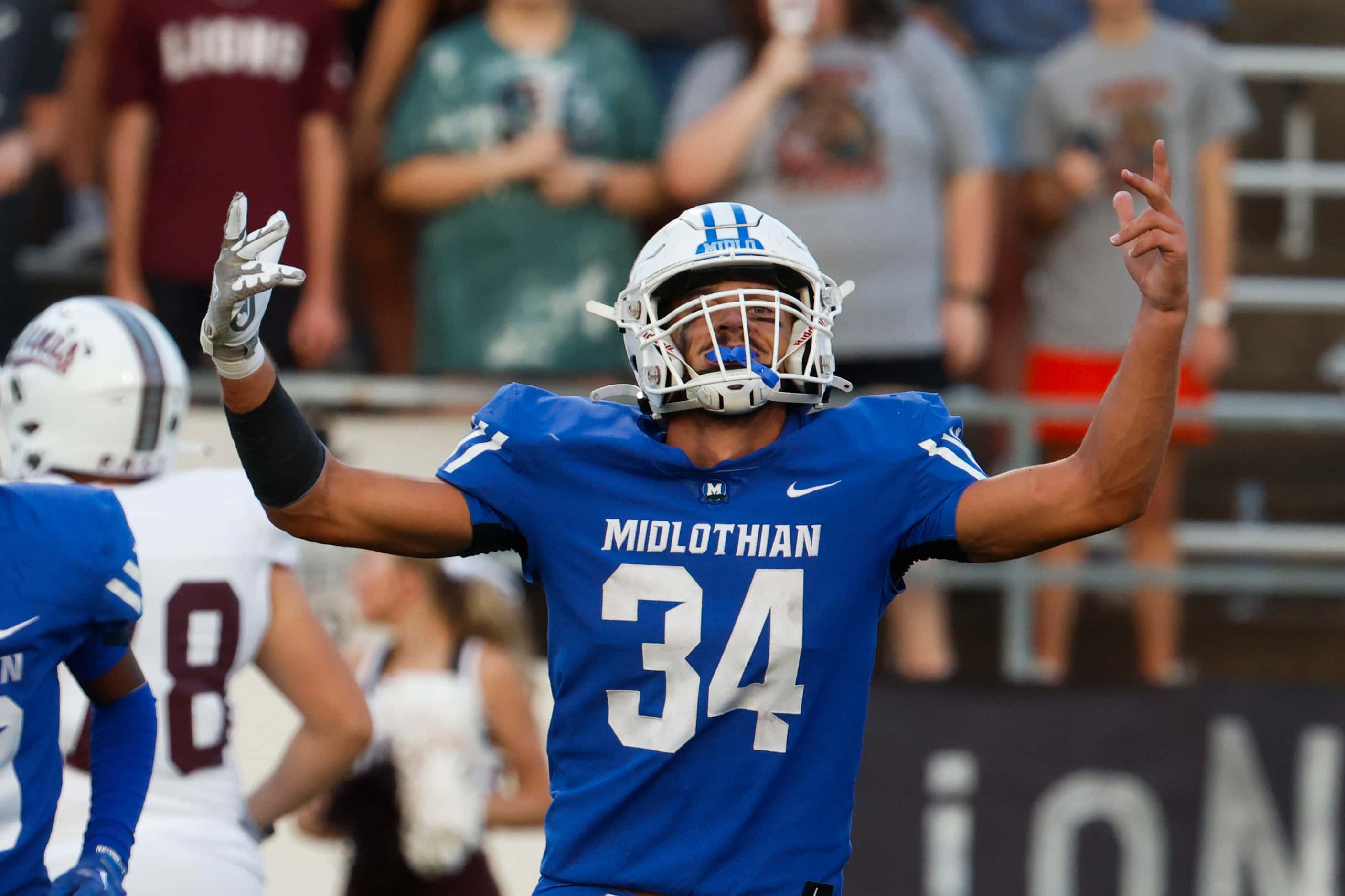 Midlothian high’s Jack Ashley (34) cheers after an intercept during the first half of a...