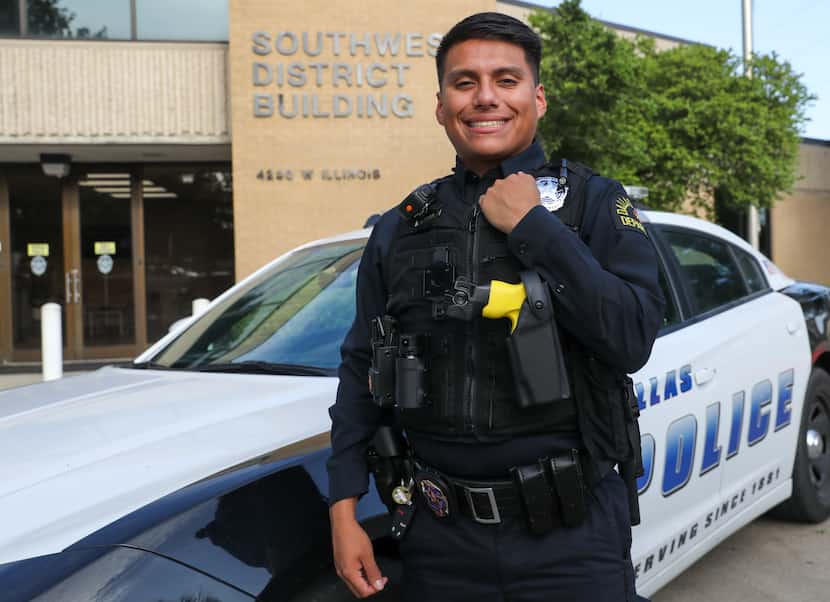 Eric Aranda, a new police officer with the Dallas Police Department, poses by a patrol car...