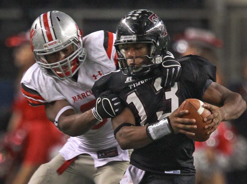 Timberview QB Charles Taylor (13) is tackled by Marcus DL Josh Carraway  (6) in the second...