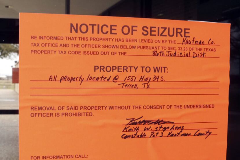 Notice of Seizure signs are placed on the front door and throughout the property of...